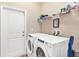 Bright laundry room with washer and dryer and a shelf above for storage at 7732 Sloewood Dr, Leesburg, FL 34748