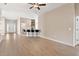 Spacious living room with wood floors, ceiling fan, and an open layout to the kitchen at 7732 Sloewood Dr, Leesburg, FL 34748