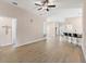 Open living room showcasing wood floors, neutral paint, ceiling fan, and access to other rooms at 7732 Sloewood Dr, Leesburg, FL 34748