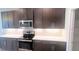 Contemporary kitchen features stainless steel appliances and dark cabinetry at 1867 Holden Ridge Lane, Clermont, FL 34715