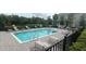 Community pool featuring lounge chairs, tables, and greenery in a fenced-in area at 1867 Holden Ridge Lane, Clermont, FL 34715