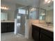 Modern bathroom with double sinks and a glass-enclosed shower at 2324 Juniper Berry Dr, Minneola, FL 34715