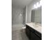 Modern bathroom featuring marble-look shower tiles, stylish vanity, and fixtures at 2324 Juniper Berry Dr, Minneola, FL 34715