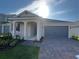 Inviting single-story home with a brick paved driveway, a covered entry and a two-car garage at 2324 Juniper Berry Dr, Minneola, FL 34715