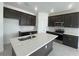 Modern kitchen featuring dark wood cabinets, stainless steel appliances, and a large island at 2324 Juniper Berry Dr, Minneola, FL 34715