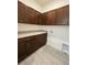 Laundry room featuring ample cabinet space, granite counters, and tiled flooring at 2324 Juniper Berry Dr, Minneola, FL 34715
