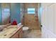 Bathroom featuring a light vanity, toilet, and glass-enclosed shower with neutral-colored tile at 2947 Aldrich St, Eustis, FL 32726