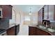A view of the spacious kitchen with dark cabinets, granite counters, stainless steel sink, and tile flooring at 2947 Aldrich St, Eustis, FL 32726