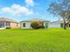 Home backyard showcasing a well maintained lawn, a blue back door and blue sky at 5317 Butterfly Ct, Leesburg, FL 34748