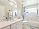 Bathroom features a single sink vanity, a toilet, a mirror, and a shower-tub combo with blue accents at 5317 Butterfly Ct, Leesburg, FL 34748