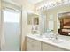 Bright bathroom boasts a double sink vanity, a large mirror with decorative lighting, and a walk-in shower at 5317 Butterfly Ct, Leesburg, FL 34748
