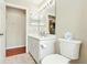 Bright bathroom features a toilet, a mirror with lighting, and a single sink vanity with decorative hardware at 5317 Butterfly Ct, Leesburg, FL 34748