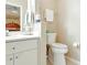 Bright bathroom features a toilet with white tiling and fixtures, a small rack for toiletries, and decorative molding at 5317 Butterfly Ct, Leesburg, FL 34748