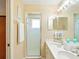 Well-lit bathroom offers a double sink vanity with a walk-in shower, a large mirror, and elegant decor at 5317 Butterfly Ct, Leesburg, FL 34748