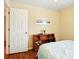 Cozy bedroom featuring wood floors, a wooden bookshelf, and neutral colored walls at 5317 Butterfly Ct, Leesburg, FL 34748