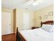 Neutral bedroom showcases wood floors, white doors, and a wooden bed frame with cozy bedding at 5317 Butterfly Ct, Leesburg, FL 34748