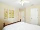 Light and airy bedroom featuring white walls, wood floors, and a wooden bed frame with minimalist decor at 5317 Butterfly Ct, Leesburg, FL 34748