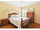Traditional bedroom with wood floors, a decorative wooden bed frame, and matching wood furniture at 5317 Butterfly Ct, Leesburg, FL 34748