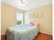 Bright bedroom features a ceiling fan, wood floors, and a sunlit window at 5317 Butterfly Ct, Leesburg, FL 34748