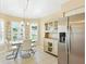 Light and airy dining area with modern chandelier, and stainless steel refrigerator at 5317 Butterfly Ct, Leesburg, FL 34748