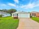 Charming single-story home with a well-manicured lawn, light blue siding, and a two-car garage at 5317 Butterfly Ct, Leesburg, FL 34748