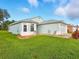 Well-maintained home with light blue exterior, neat landscaping, and an attached two-car garage at 5317 Butterfly Ct, Leesburg, FL 34748