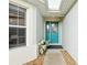 Inviting entryway featuring a turquoise front door, skylight, and decorative floral arrangement at 5317 Butterfly Ct, Leesburg, FL 34748