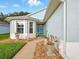 Inviting front entrance featuring a decorative blue door, bay window, and meticulously landscaped walkway at 5317 Butterfly Ct, Leesburg, FL 34748