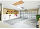 Spacious two-car garage with pegboard, shelving, and ample room for vehicles at 5317 Butterfly Ct, Leesburg, FL 34748