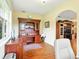 Home office featuring wooden desk, shelves, and storage, open to entertainment space at 5317 Butterfly Ct, Leesburg, FL 34748