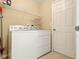 Convenient laundry room featuring a washer, dryer, and shelving at 5317 Butterfly Ct, Leesburg, FL 34748