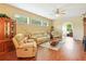 Cozy living room featuring hardwood floors, ample natural light, and comfortable seating at 5317 Butterfly Ct, Leesburg, FL 34748