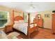 Cozy primary bedroom with a four-poster bed, hardwood floors, and soft lighting at 5317 Butterfly Ct, Leesburg, FL 34748