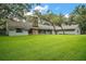 A wide shot of the backyard featuring a well-maintained lawn and mature trees at 9335 Silver Lake Dr, Leesburg, FL 34788