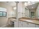 Bright bathroom featuring double sinks with granite countertops and white cabinetry at 9335 Silver Lake Dr, Leesburg, FL 34788