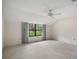 Carpeted bedroom with vaulted ceilings and a view of the backyard at 9335 Silver Lake Dr, Leesburg, FL 34788