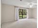 Bright bedroom featuring a large window with backyard views and a ceiling fan at 9335 Silver Lake Dr, Leesburg, FL 34788