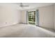 Carpeted bedroom featuring a ceiling fan and a large window with backyard views at 9335 Silver Lake Dr, Leesburg, FL 34788