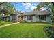 Charming single-story home featuring a stone facade, manicured lawn, and mature trees at 9335 Silver Lake Dr, Leesburg, FL 34788