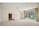 Bright, carpeted living room with a large picture window and high ceilings at 9335 Silver Lake Dr, Leesburg, FL 34788
