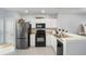 Efficient kitchen with white cabinets, black appliances, and tiled flooring at 4904 Sw 45Th St, Ocala, FL 34474