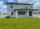 View of the home's backyard featuring a covered patio and lush green lawn at 2290 Raven Ridge Rd, Minneola, FL 34715