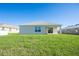 Rear view of the house showcasing the grassy backyard and patio area at 9200 Se 48Th Court Rd, Ocala, FL 34480