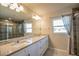 Bathroom featuring double granite vanity and a walk-in shower with a glass door at 9200 Se 48Th Court Rd, Ocala, FL 34480