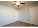 This bedroom has a ceiling fan, two doors, wood-look flooring, and neutral-colored walls at 9200 Se 48Th Court Rd, Ocala, FL 34480