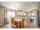 Bright dining area with modern chandelier, leading to the kitchen featuring stainless steel appliances at 9200 Se 48Th Court Rd, Ocala, FL 34480