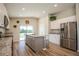 This open kitchen offers white and gray cabinets, a center island with bar seating, stainless appliances, and granite countertops at 9200 Se 48Th Court Rd, Ocala, FL 34480