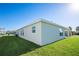 Side view of the home with well-maintained lawn and covered patio at 9200 Se 48Th Court Rd, Ocala, FL 34480