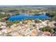 Wide aerial shot of the house showing proximity to lake and neighborhood, surrounded by mature trees at 781 Ne 130Th Ter, Silver Springs, FL 34488