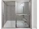 Modern bathroom features gray tiling with sliding glass shower doors at 781 Ne 130Th Ter, Silver Springs, FL 34488